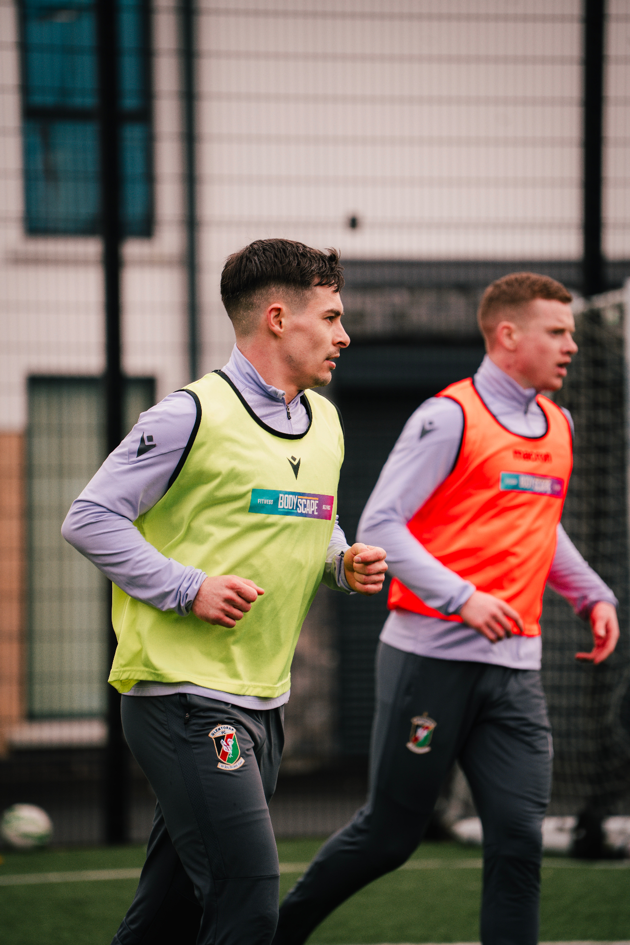 Glentoran FC players jogging through a warm-up at the club training ground