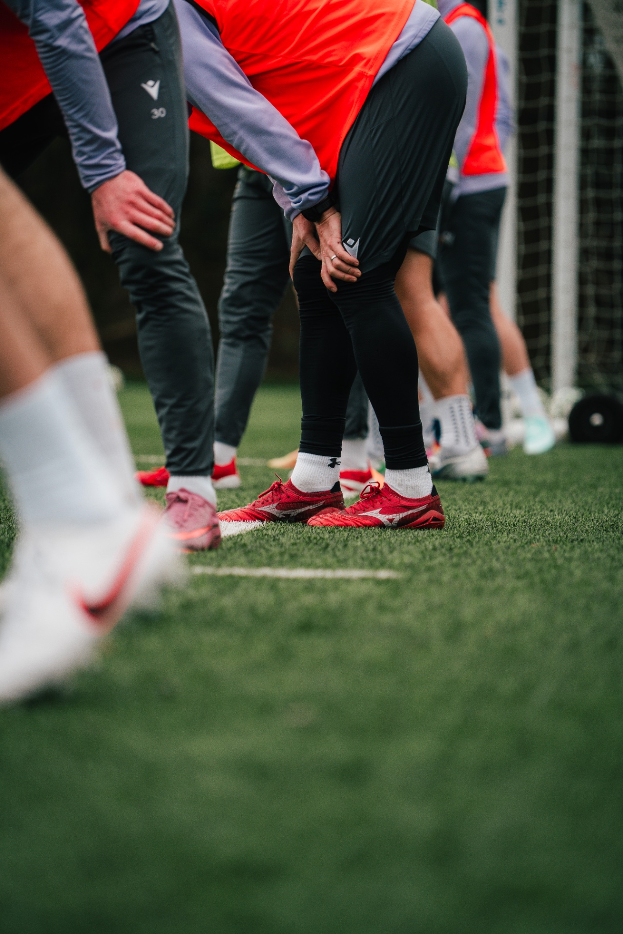 Squad stretching in training bibs at a professional club session